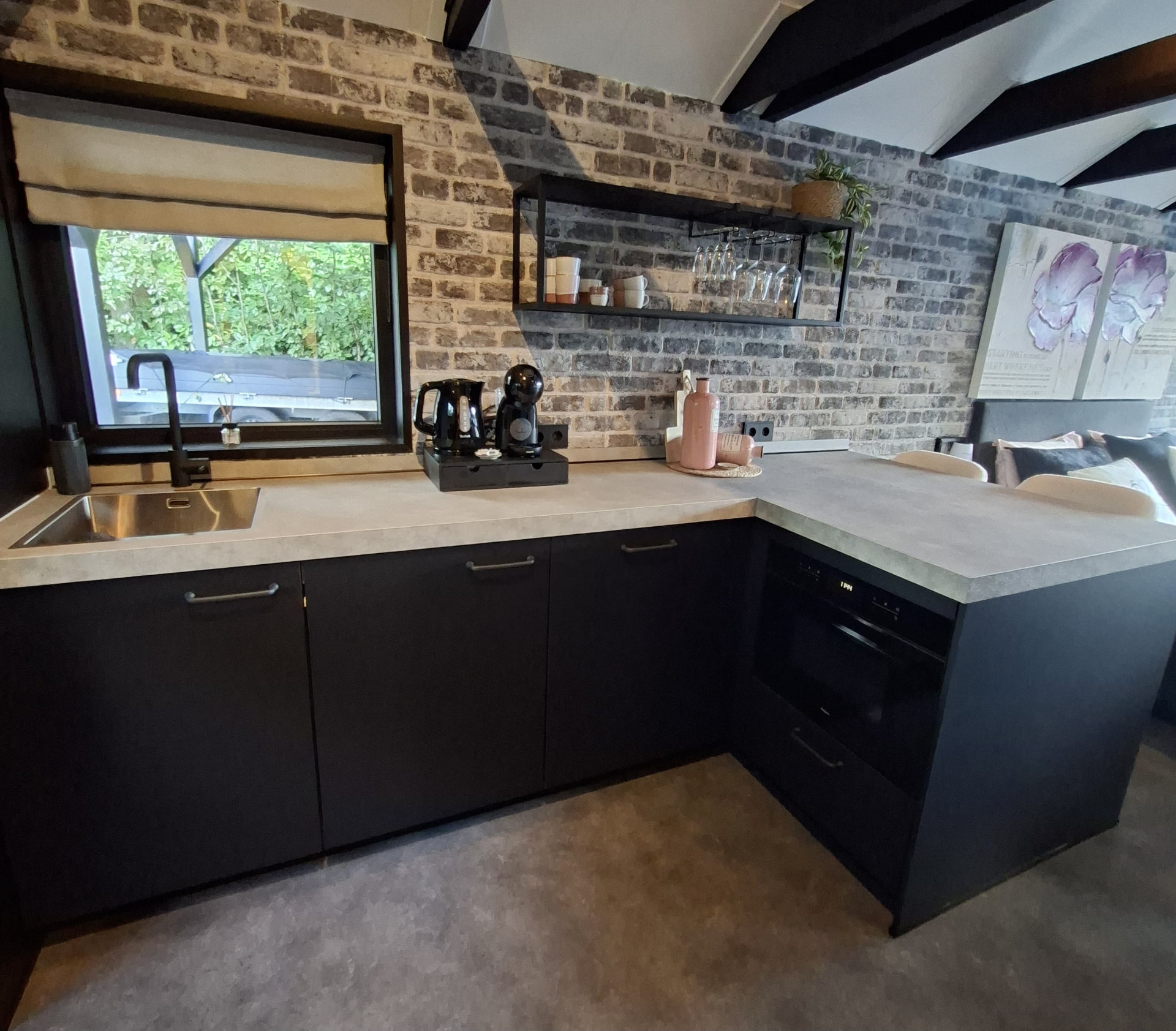 Volledig uitgeruste keuken met bakstenen muur