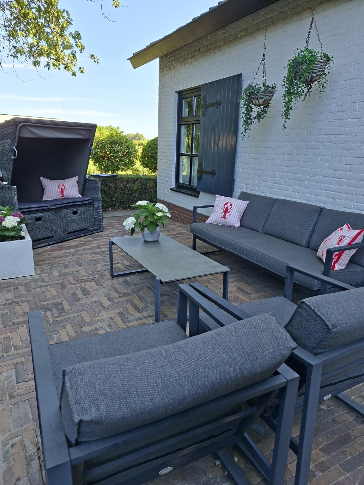 Ruim terras met loungeset en strandstoel
