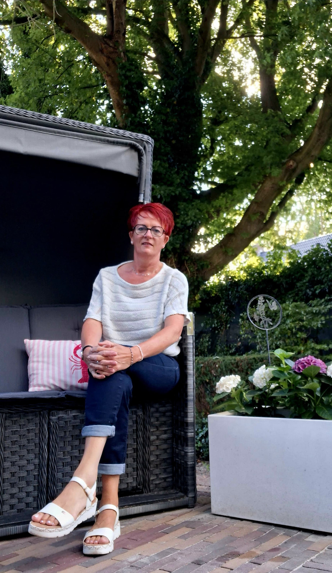 Isabel, gastvrouw van Isa's B&B, in de tuin bij de strandstoel