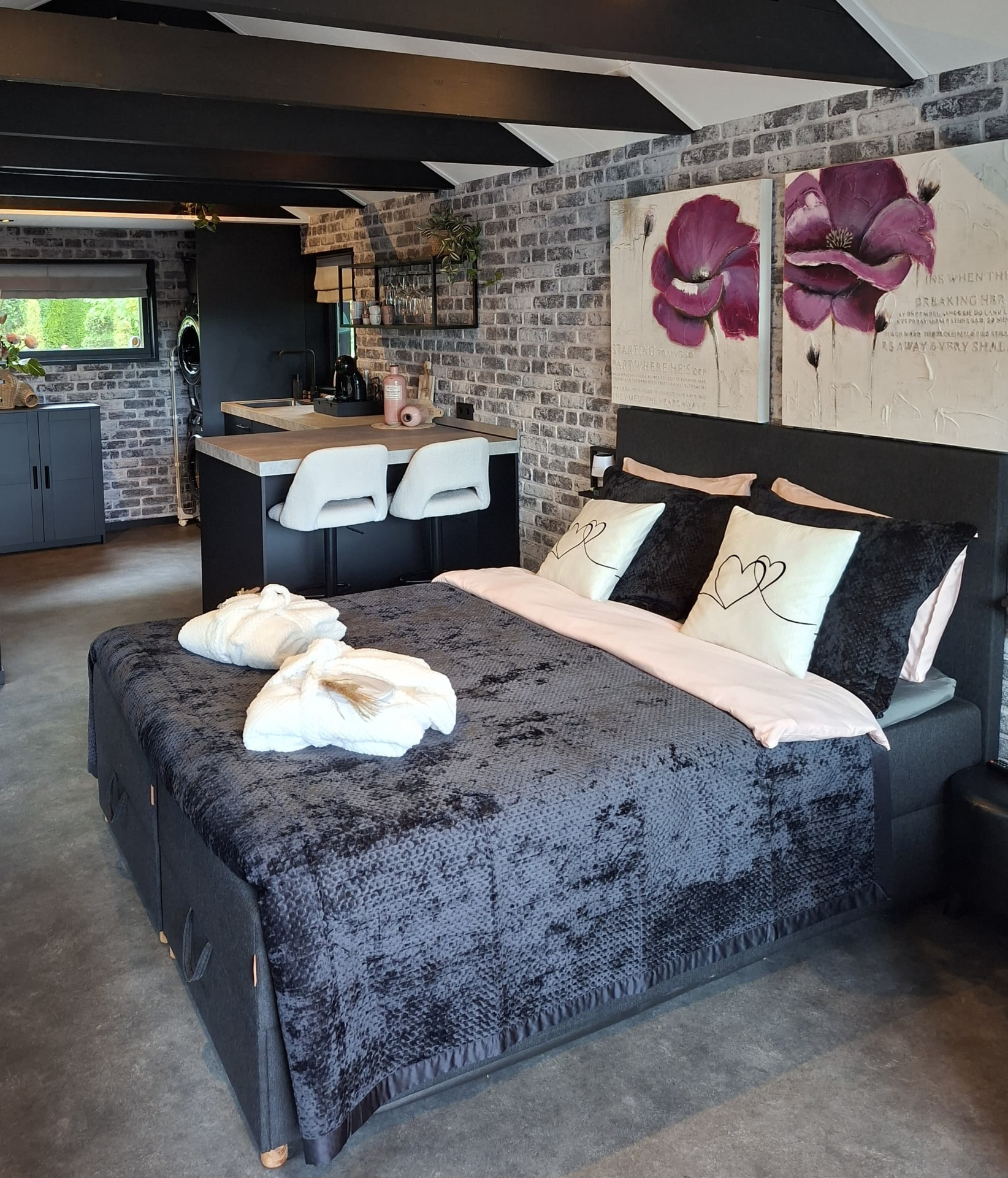 Tweepersoonsbed met open keuken in het Tiny House